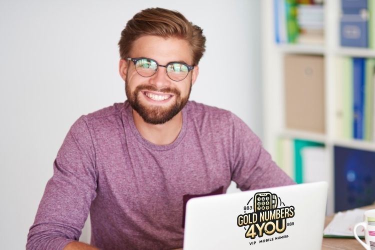 Smiling man with laptop showing Gold Numbers 4 You logo – UK VIP mobile numbers